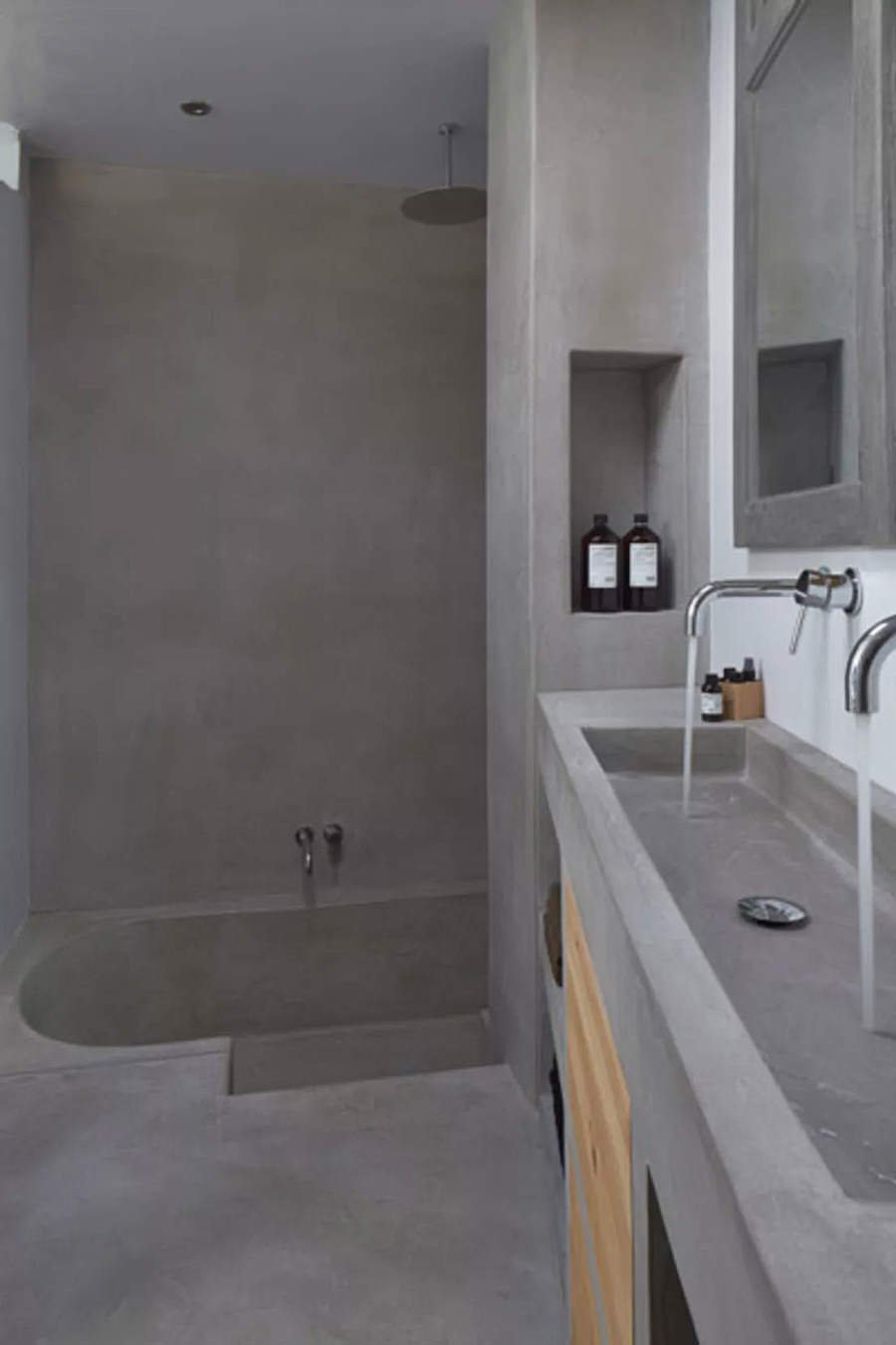 Stupendo bagno in muratura dalle superfici omogenee, con vasca, lavandino, mobili e nicchie create in cemento. Una perfetta qualificazione estetica e strutturale della stanza.