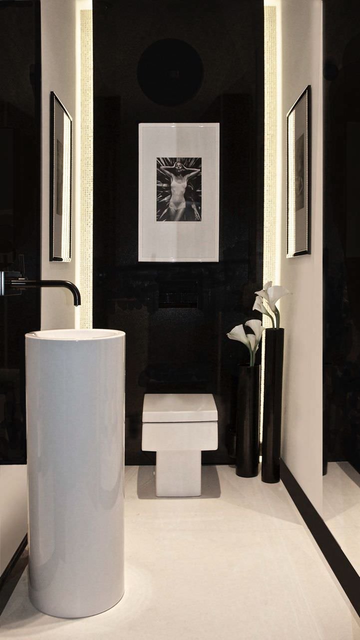 Stupendo bagno moderno ed elegante in bianco e nero. Lavabo alto e stretto che ottimizza lo spazio. Illuminazione a led ad angolo parete. Idee ristrutturazione bagni stretti e lunghi.