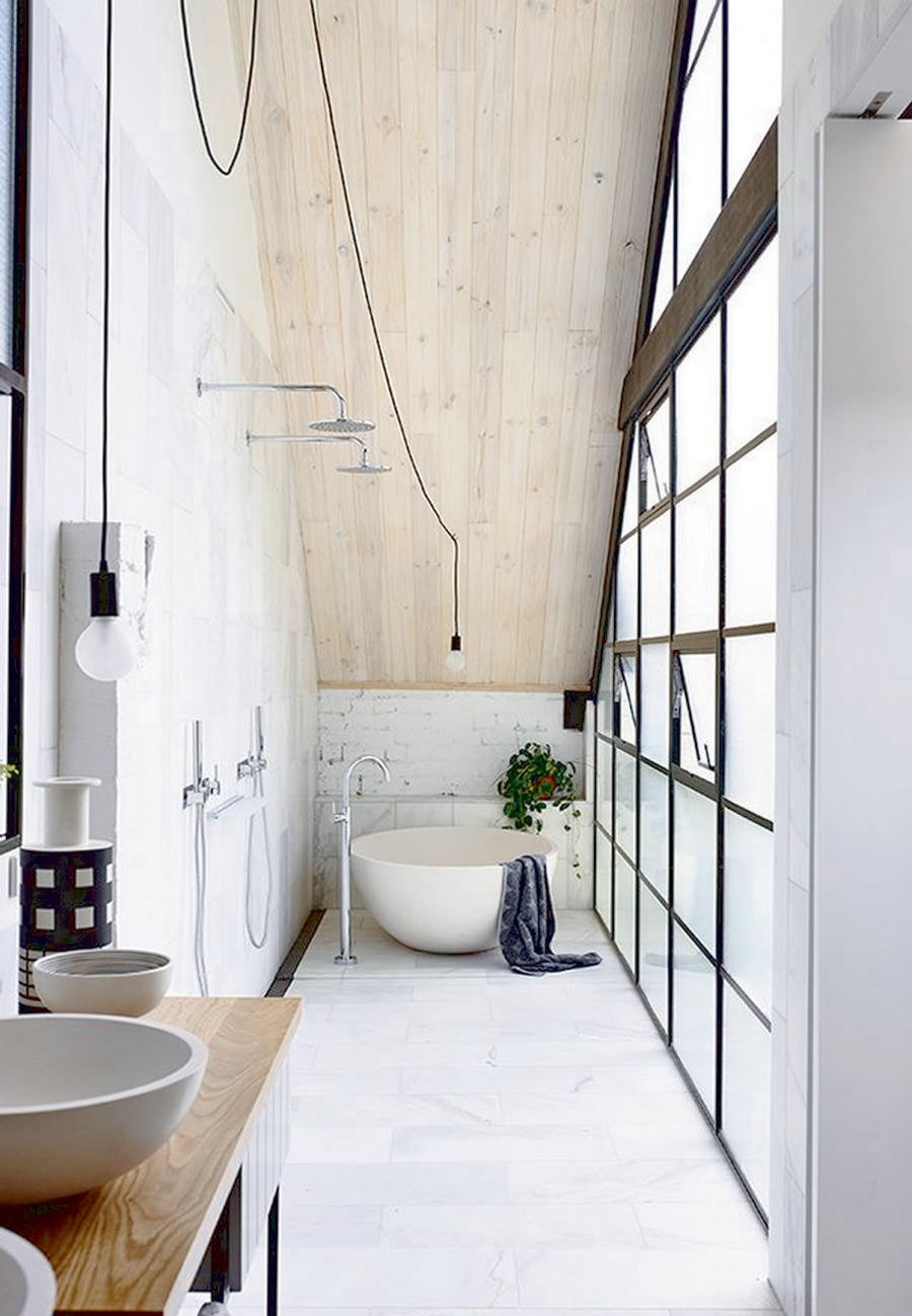 Particolare bagno molto lungo e stretto con doppia doccia e piccola vasca circolare. Pavimenti e rivestimento in marmo e soffitto in legno.