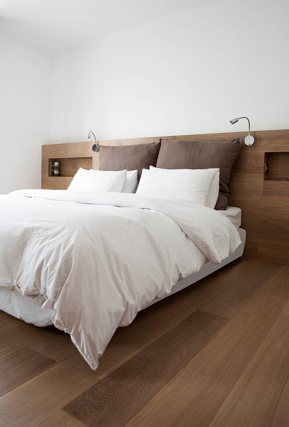 Stanza da letto con linee minimal moderne con testata in legno rovere. Colori bianco e marrone