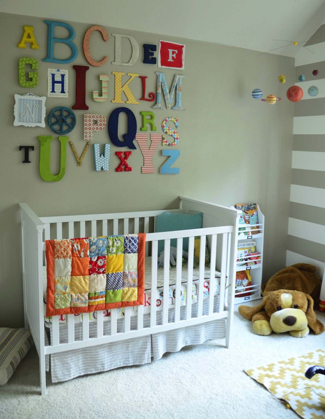 Cameretta per bimbo neonato decorate con delle lettere dell'alfabeto multicolori - in contrasto con le pareti colore grigio tortora - semplice, allegra e gioiosa - idee camerette neonati