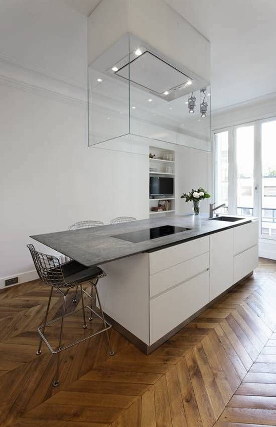 Stupenda cucina moderna con isola, mobili in laminato bianco, top in marmo e pavimenti in legno massello. Cappa in vetro di grande effetto