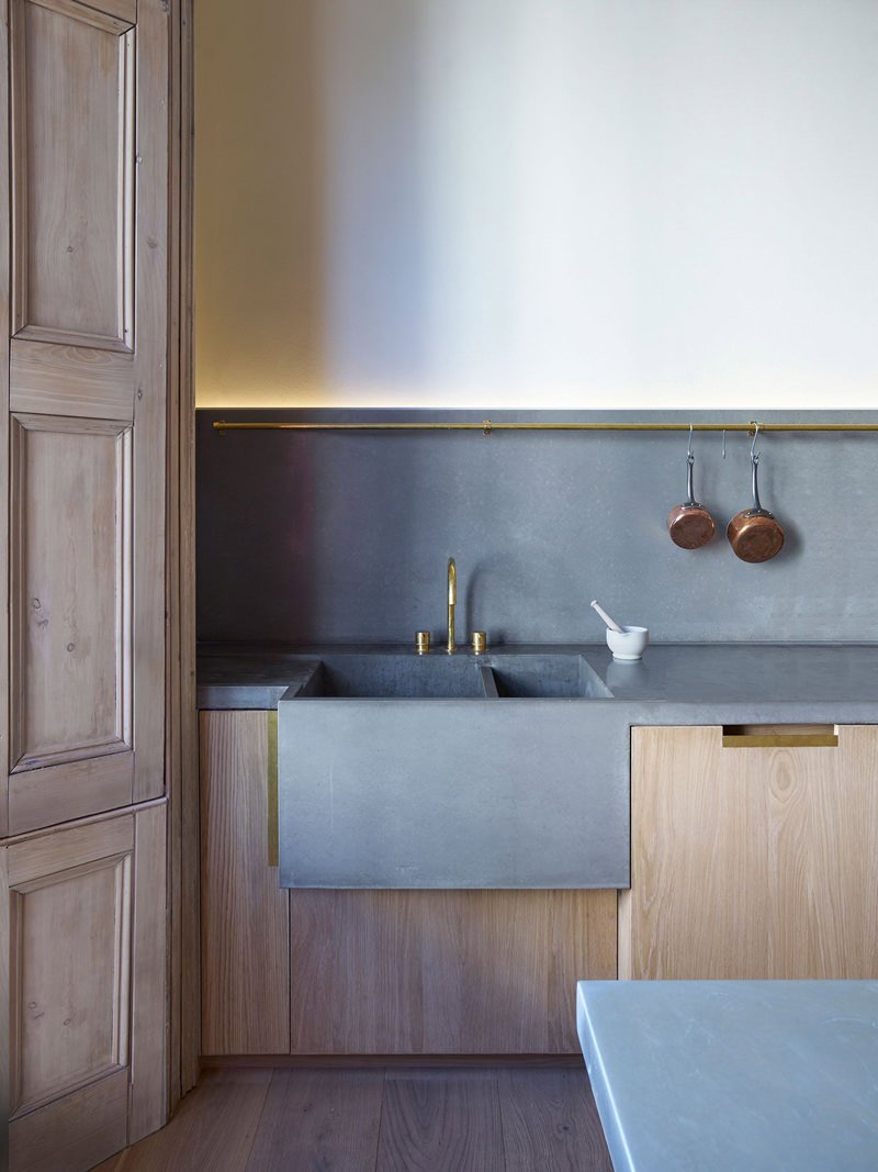 Idea cucina moderna in muratura con top, lavabo e paraschizzi che sono un'unico pezzo. Interessante luce a led ed i vari dettagli in metallo dorato.