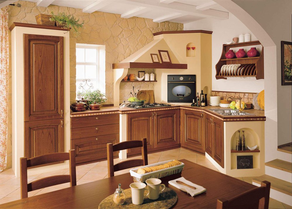 Particolari in legno noce per questa cucina in muratura classica - pareti in pietra giallo ocra