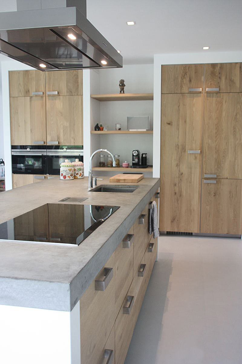 Progetto cucina in muratura moderna - isola centrale con top in cemento e  sportelli in rovere con grandi maniglie in acciaio inox