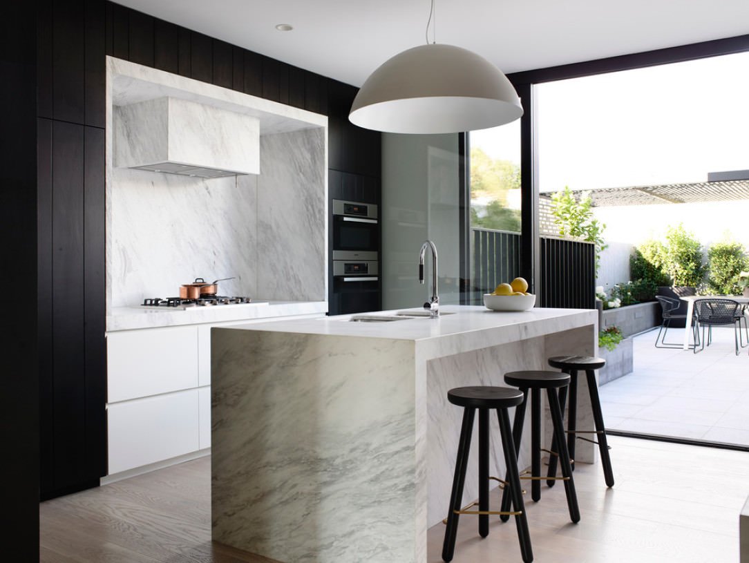 Idea cucina moderna con isola centrale in marmo di Carrara, mobili in ebano ed eleganti sedie - arredo cucine in legno