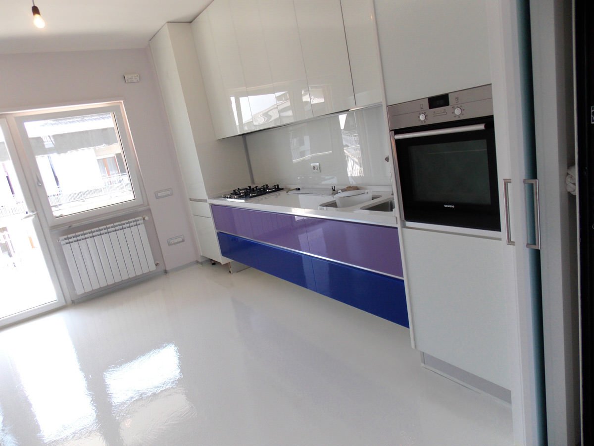 Idea pavimento cucina in resina colore bianco - mobili laccati bianchi con alcuni sportelli colorati - pavimenti senza piastrelle per cucine moderne