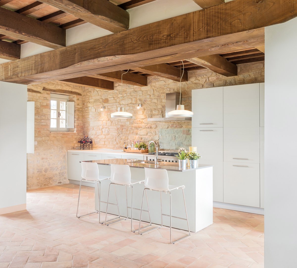 Cucina rustica moderna con pavimento in cotto, mobili in laminato bianco e travi in legno - idee piastrelle cucine rustiche moderne