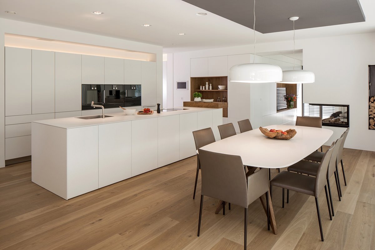 Cucina moderna bianca, con isola e tavolo da pranzo, con pavimenti in legno colore chiaro - Idea ristrutturazione cucina