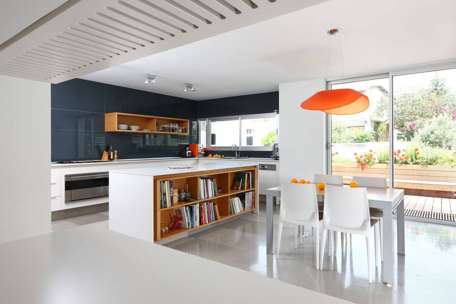 Open space molto luminoso in bianco e nero con alcuni tocchi di colore - rivestimento cucina in lastra di vetro, colore grigio scuro - rivestimenti per cucine moderne