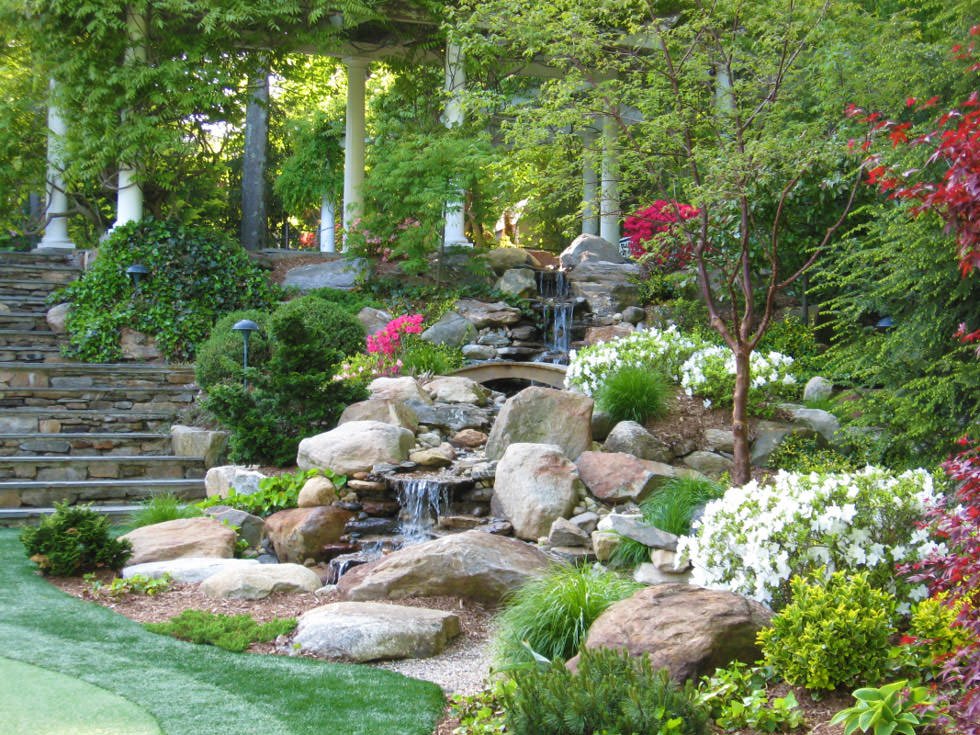 Idee per realizzazione un giardino roccioso con cascata d'acqua e scalinata in pietra naturale