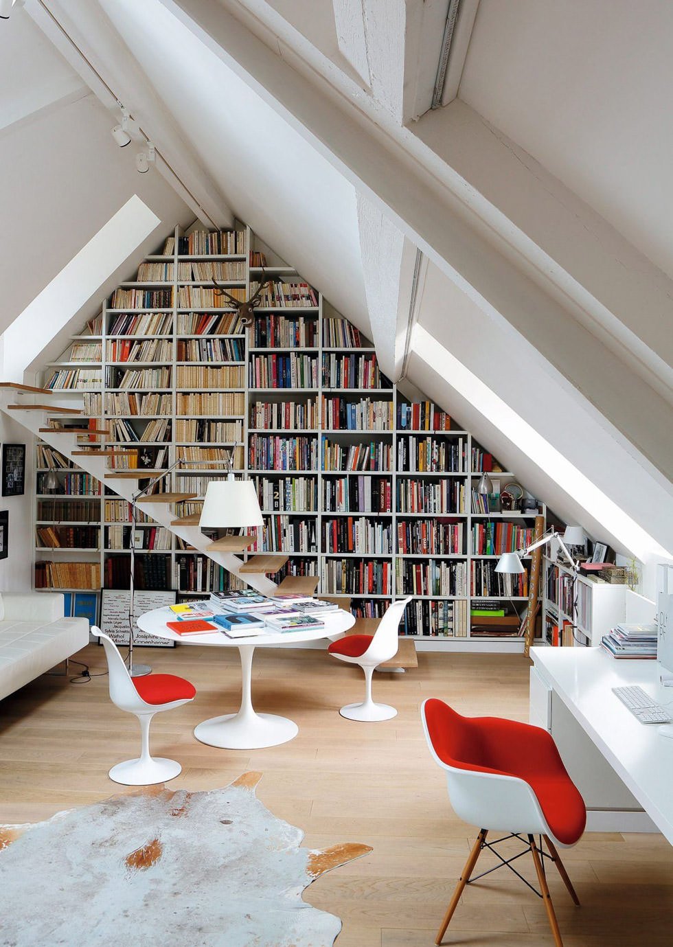 Mansarda moderna ben illuminata con lucernari sul tetto - spazio lavoro e relax con grande libreria