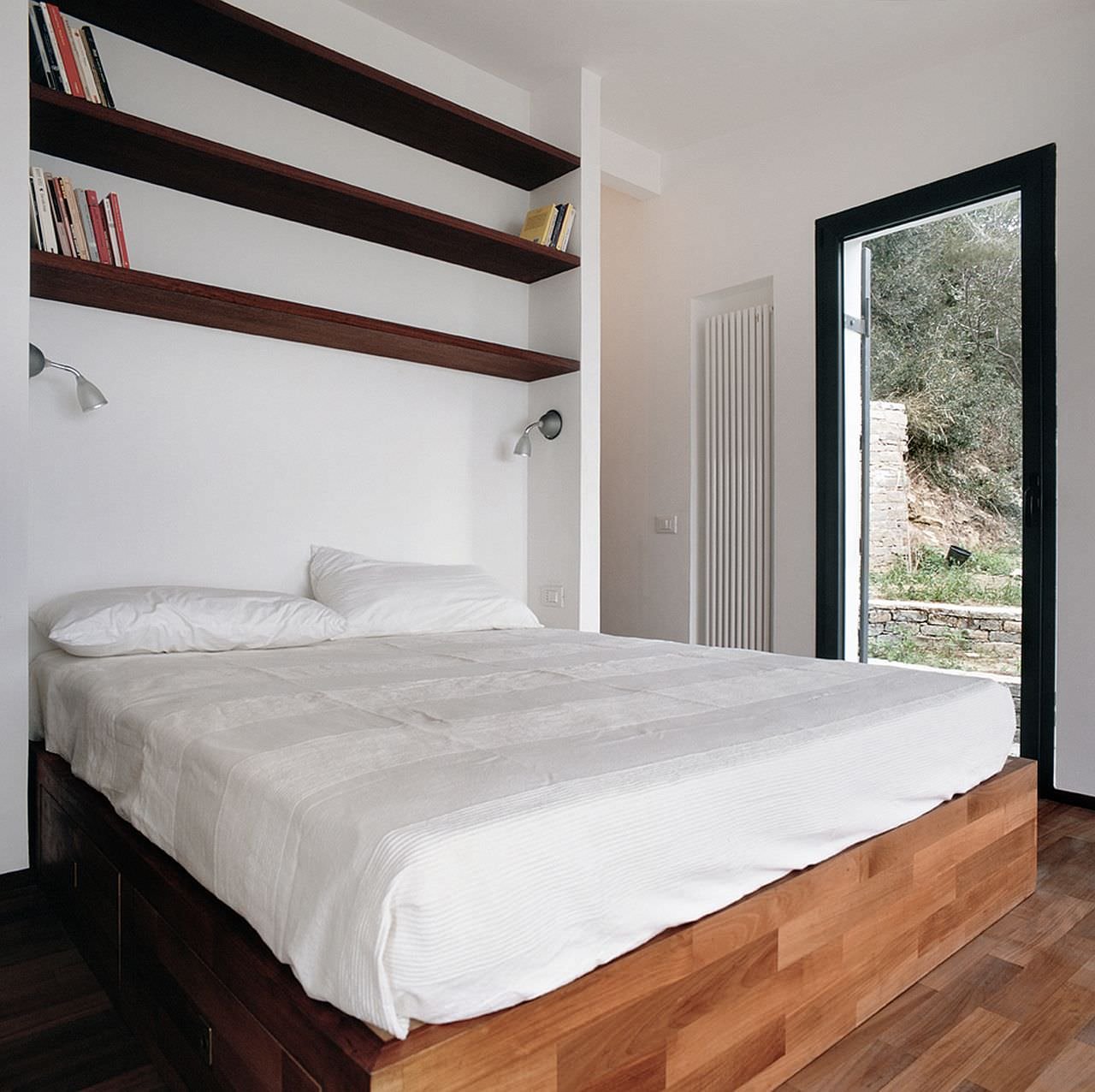 Camera da letto con grandi contenitori per sfruttare al meglio il piccolo spazio disponibile in questo piccolo appartamento di 35 mq