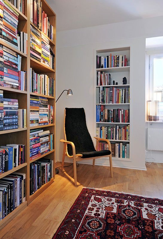 Angolo lettura casa contemporanea - unica sedia ed una grande libreria piena di libri