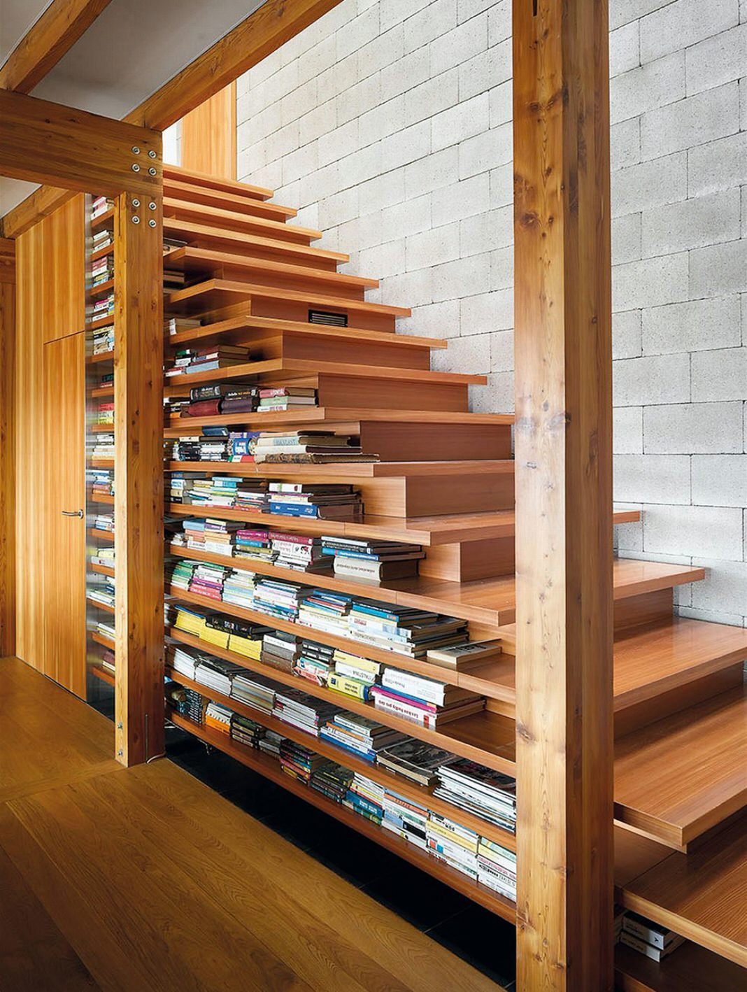 Idea geniale e pratica di progettazione, in cui la  scala diventa una perfetta libreria - modo creativo per sfruttare lo spazio sotto le scale