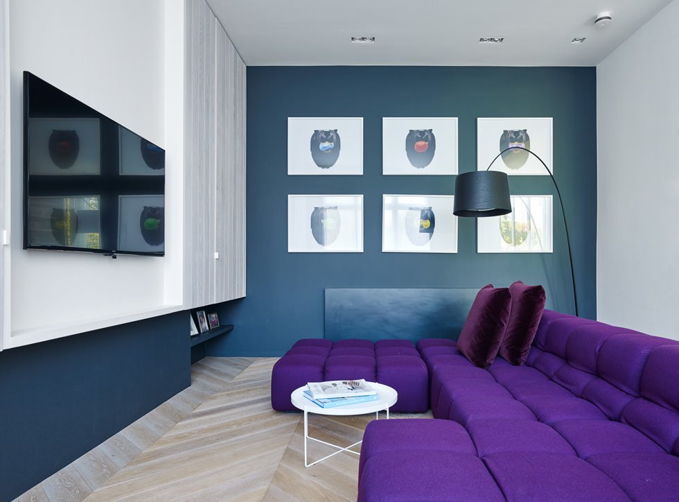 Immagine soggiorno moderno con le pareti colore blu ed il divano viola - idea semplice e moderna per dare un tocco di colore al salotto attraverso la pittura della parete