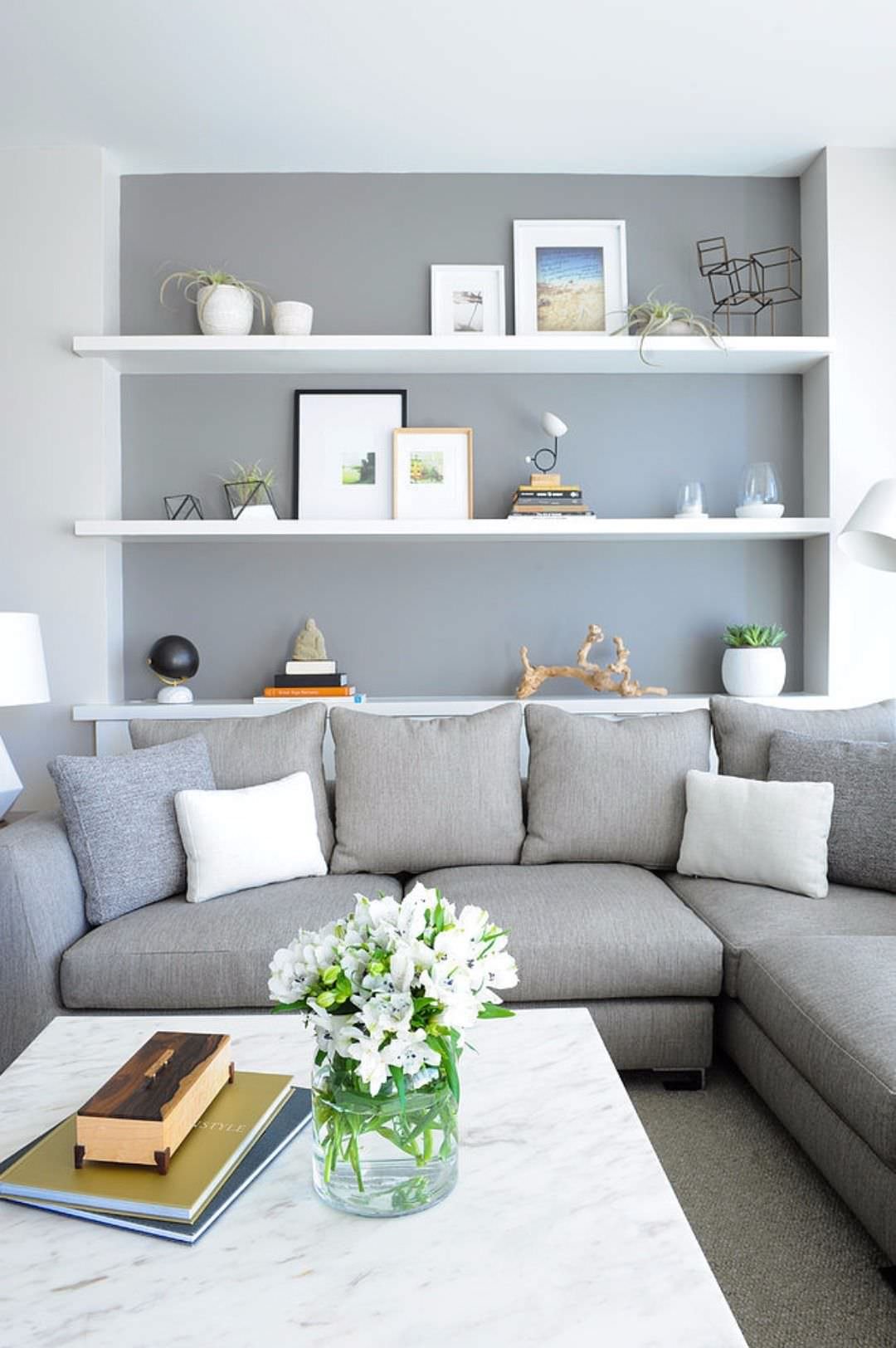 Idea soggiorno scandinavo in colori bianco e grigio - libreria costruita in una nicchia del muro - idee soggiorni contemporanei