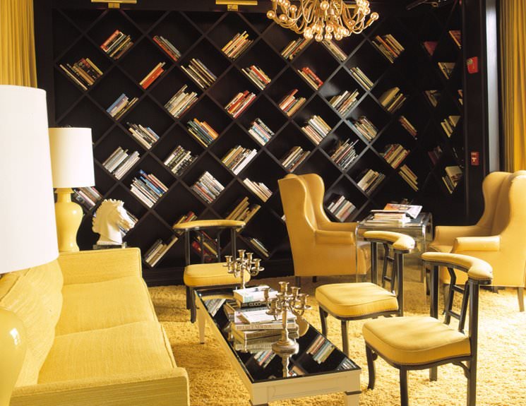 Living contemporaneo con arredi, mobili e decorazioni colore giallo e particolare design per la libreria