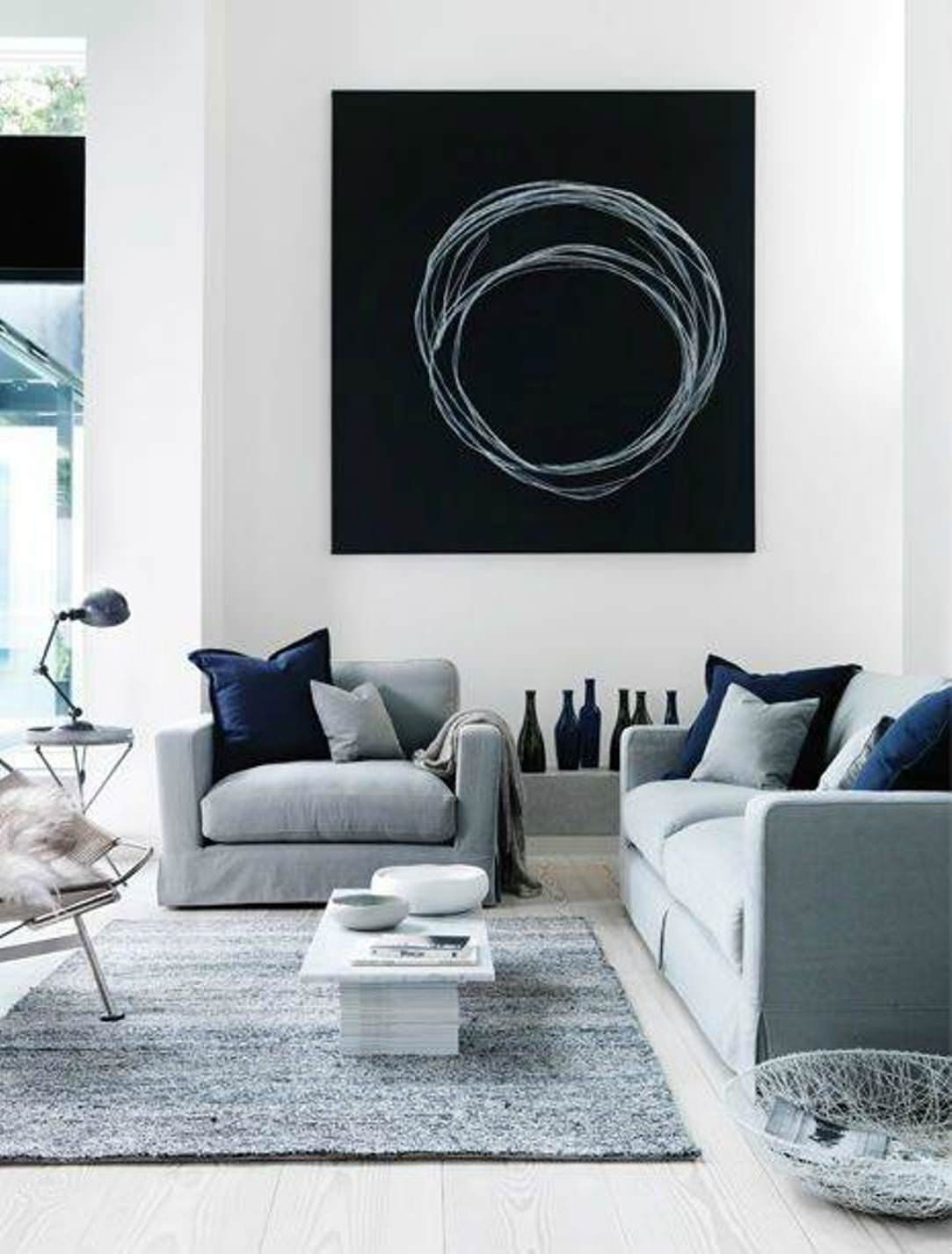 Idea soggiorno monocromo stile moderno scandinavo, con arredi colore grigio e blu. Quadro molto semplice e d'impatto in tema con l'ambiente