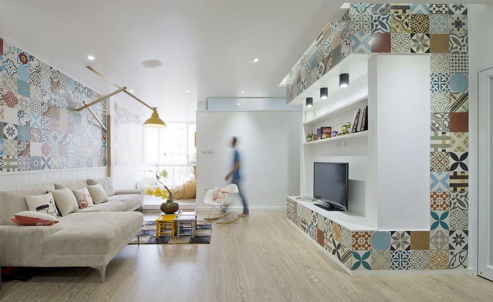 Immagine piccolo soggiorno reso moderno dal particolare rivestimento delle pareti con le piastrelle patchwork che offrono un grande impatto visivo