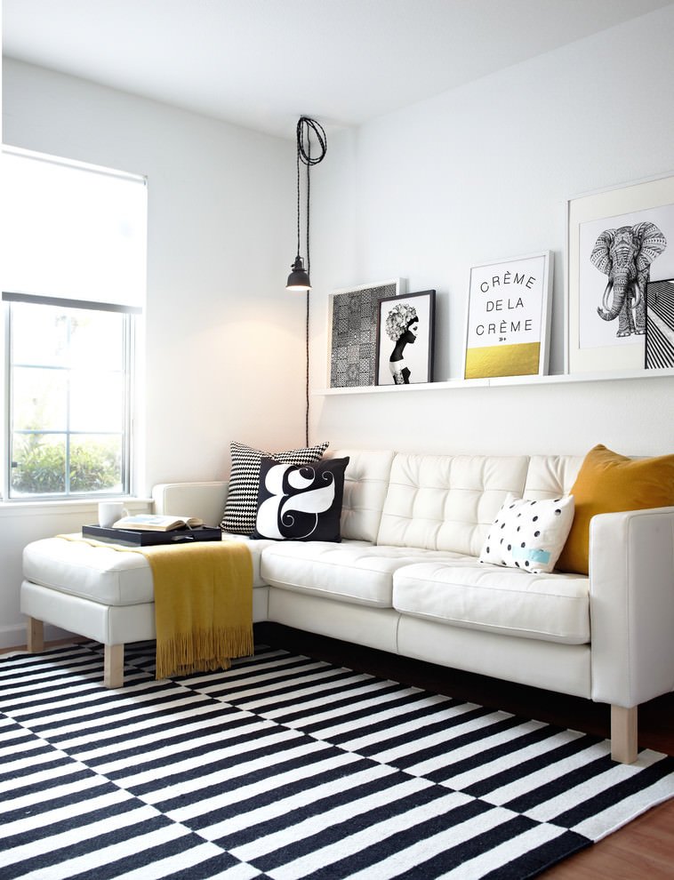 Salotto scandinavo in bianco e nero ed alcuni tocchi di colore giallo e oro che aggiungono un ulteriore dinamismo alla stanza, così come i vari disegni e motivi grafici.